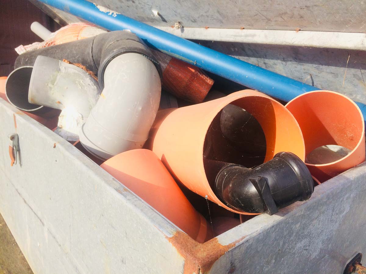 Cassa da muratore con vari tubi in plastica