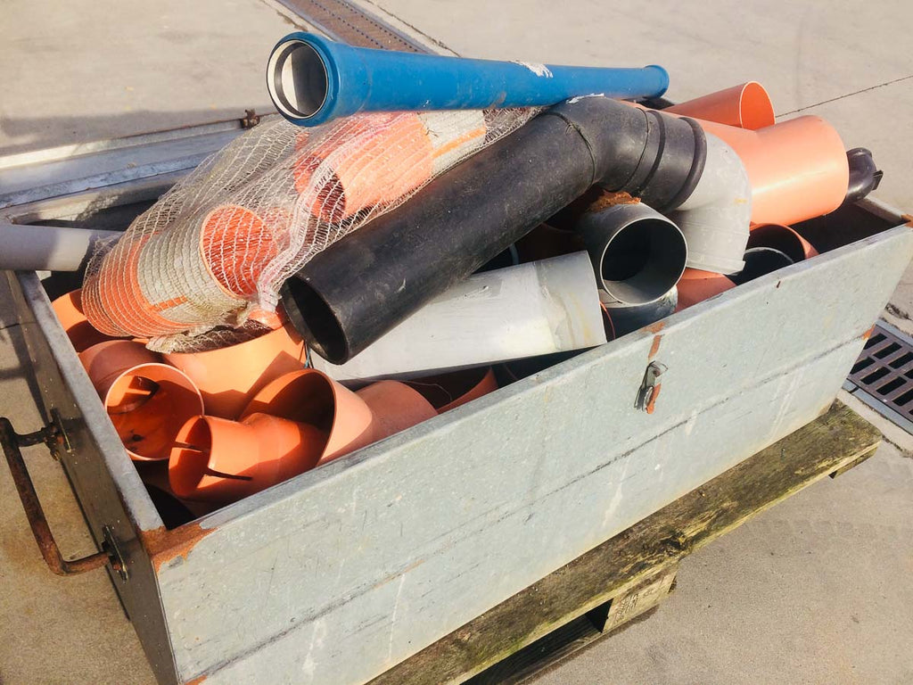 Cassa da muratore con vari tubi in plastica